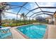 Enclosed pool and spa alongside outdoor seating area with lovely water view at 25187 Keygrass Ct, Punta Gorda, FL 33955