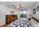 Bright bedroom with a queen bed, dresser, and access to a balcony at 25188 Marion Ave # D205, Punta Gorda, FL 33950