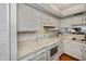 Kitchen with white cabinets, electric range, and light countertops at 25188 Marion Ave # D205, Punta Gorda, FL 33950
