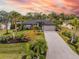 Landscaped home with driveway, showcasing a stunning sunset at 2561 Sheila Ln, North Port, FL 34286