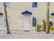 Exterior view of a light yellow building with a blue awning and white door at 26346 Rampart Blvd # 904, Punta Gorda, FL 33983