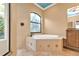 Bathroom with garden tub, walk-in shower, and large window at 3000 Narcissus Ter, North Port, FL 34286