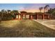 Stunning house exterior at sunset, three-car garage, and manicured lawn at 3000 Narcissus Ter, North Port, FL 34286