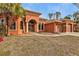 Orange house with a three-car garage and beautiful landscaping at 3000 Narcissus Ter, North Port, FL 34286