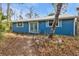 Blue house with double doors and shutters, situated in a natural setting at 3000 Narcissus Ter, North Port, FL 34286