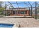 Screened patio with brick pavers and view of the pool and home at 3000 Narcissus Ter, North Port, FL 34286