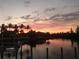 Beautiful sunset view over canal, palm trees and waterfront homes at 3513 Terin Ct, Punta Gorda, FL 33950