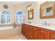 Elegant bathroom with double vanity, soaking tub, and tile floors at 3663 Whippoorwill Blvd, Punta Gorda, FL 33950