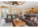 Open concept living room with leather furniture and access to kitchen at 3663 Whippoorwill Blvd, Punta Gorda, FL 33950