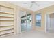 Bright bedroom with built-in shelves and sliding glass doors leading to a pool view at 3932 Madrid Ct, Punta Gorda, FL 33950