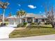 House exterior featuring a two-car garage and tropical landscaping at 3932 Madrid Ct, Punta Gorda, FL 33950