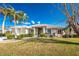 One-story house with a light-tan exterior, lush landscaping, and a two-car garage at 3932 Madrid Ct, Punta Gorda, FL 33950