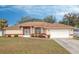 Tan house with brown roof, white garage door, and landscaped yard at 4046 Lubec Ave, North Port, FL 34287