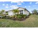 Well-maintained house with lush landscaping and a side view of the garage at 42115 Edgewater Dr, Punta Gorda, FL 33982