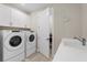 Bright laundry room with white cabinets and Whirlpool washer and dryer at 42115 Edgewater Dr, Punta Gorda, FL 33982