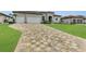 Large driveway with a mix of pavers leading to a three-car garage at 4218 Vasco St, Punta Gorda, FL 33950
