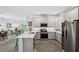 Open concept kitchen with island, stainless steel appliances, and view into living room at 43620 Sparrow Dr, Punta Gorda, FL 33982