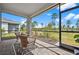 Relaxing screened porch with wicker furniture and a view of nature at 43620 Sparrow Dr, Punta Gorda, FL 33982