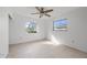 A bedroom with tile floors, ceiling fan, and two windows at 450 Capri Isles Ct, Punta Gorda, FL 33950