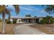 Ranch-style home with circular driveway, metal roof, and mature landscaping at 450 Capri Isles Ct, Punta Gorda, FL 33950
