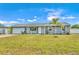 Newly renovated home with gray exterior, white garage door, and landscaped lawn at 745 Kellstadt Nw St, Port Charlotte, FL 33952