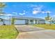 Gray house with a white garage door and driveway, surrounded by a well-maintained lawn at 745 Kellstadt Nw St, Port Charlotte, FL 33952