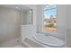 Spa-like bathroom with a soaking tub, shower, and large window at 8326 Creekview Ln, Englewood, FL 34224