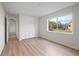 Bright bedroom featuring wood-look floors and large window at 8326 Creekview Ln, Englewood, FL 34224