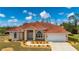 Single-story home with tile roof, landscaped yard, and attached garage at 8326 Creekview Ln, Englewood, FL 34224