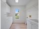 Laundry room with white cabinets and window at 8326 Creekview Ln, Englewood, FL 34224