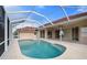 Kidney-shaped pool with screened enclosure and concrete deck at 8326 Creekview Ln, Englewood, FL 34224