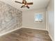Bedroom with wood floors, accent wall, and window shutters at 87 Vivante Blvd # 403, Punta Gorda, FL 33950