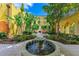 Inviting courtyard with fountain, lush landscaping, and fireplace at 87 Vivante Blvd # 403, Punta Gorda, FL 33950