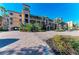 Mediterranean-style condo building with palm trees and paved driveway at 87 Vivante Blvd # 403, Punta Gorda, FL 33950