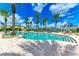Freeform pool with lounge chairs and palm trees at 87 Vivante Blvd # 403, Punta Gorda, FL 33950
