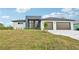Modern two-story house with a three-car garage and landscaped lawn at 9516 President Cir, Port Charlotte, FL 33981