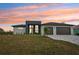 Modern home's exterior with two-car garage and sunset view at 9516 President Cir, Port Charlotte, FL 33981