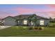 Evening view of a teal house with landscaping and a two-car garage at 1188 Paraclete Rd, Punta Gorda, FL 33983