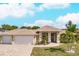 House exterior showcasing a three-car garage and landscaped yard at 13039 Ridgely Cir, Port Charlotte, FL 33981