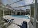 Community pool area with lounge chairs and a screened enclosure at 1347 Hedgewood Cir, North Port, FL 34288