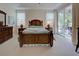 Main bedroom with wooden bed frame and direct access to patio at 1347 Hedgewood Cir, North Port, FL 34288