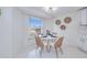 Bright dining area with white table and chairs, natural light, and terrazzo flooring at 148 Salem Nw Ave, Port Charlotte, FL 33952