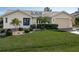 White one-story home with blue door, landscaping, and a two-car garage at 1511 Casey Key Dr, Punta Gorda, FL 33950