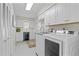 Laundry room with modern washer, dryer, and white cabinets at 1511 Casey Key Dr, Punta Gorda, FL 33950