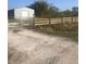 Gravel driveway leading to a metal building and wooden fence at 15570 Rasmussen Rd, Punta Gorda, FL 33982