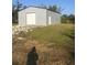 Gray metal building with a large roll-up door at 15570 Rasmussen Rd, Punta Gorda, FL 33982