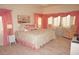 Main bedroom with king bed, pink accents, and bay window seating at 1601 Park Beach Cir # 136/18, Punta Gorda, FL 33950