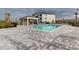 Community pool with brick pavers, covered seating, and building in background at 17565 Opal Sand Dr # 401, Venice, FL 34293