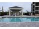 Community pool with brick pavers and covered seating area at 17565 Opal Sand Dr # 401, Venice, FL 34293