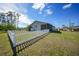 Home's backyard features a spacious grassy area and a white picket fence at 18086 Clanton Ave, Port Charlotte, FL 33948